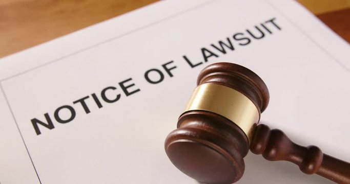 Dolly Shot Of Gavel Over Notice Of Lawsuit Text 4K