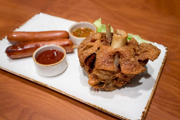 Roasted pork knuckle and sausages serve with ketchup