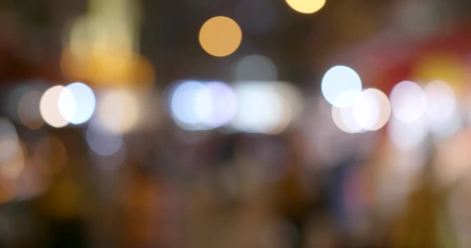 Bokeh of city with people walking in the street at night