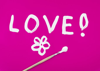 Love word with flower painted on pink background