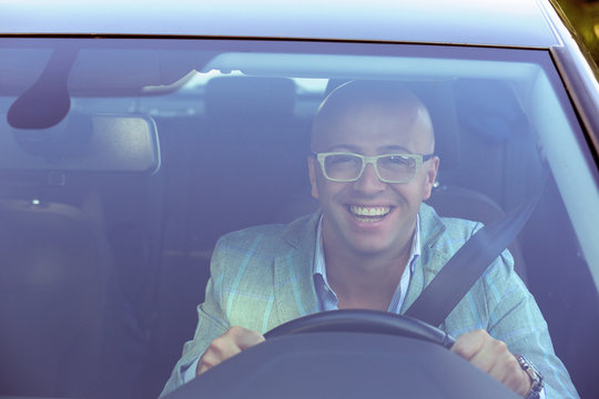 Handsome Business Man Smiling Looking Out Of His New Car Window