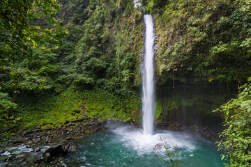 Waterfall into beautiful turquoise pool in Costa Rican rainforest