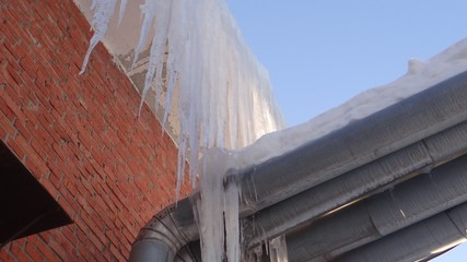 Obraz premium The snow and ice against a brick surface.