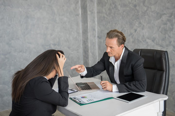Leader businessman blaming female employee at office desk. Fail business concept.