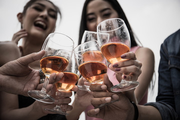 Young people with glasses of whiskey at night party.