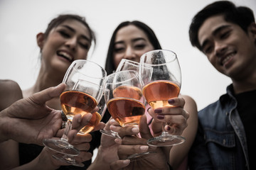 Young people with glasses of whiskey at night party.