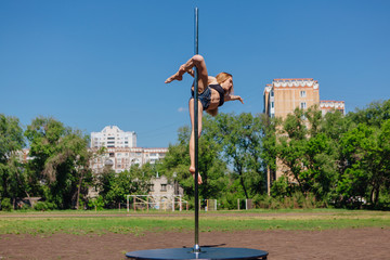 Fit attractive girl dancing near portable pole at summer day © Smile