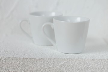 tableware mockup. Minimalist cup Mockup. white cups on a white  relief background. White cup on white background. copy space