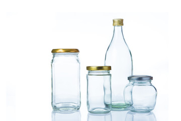 Clear glass bottles in various sizes and shapes with lids on white background