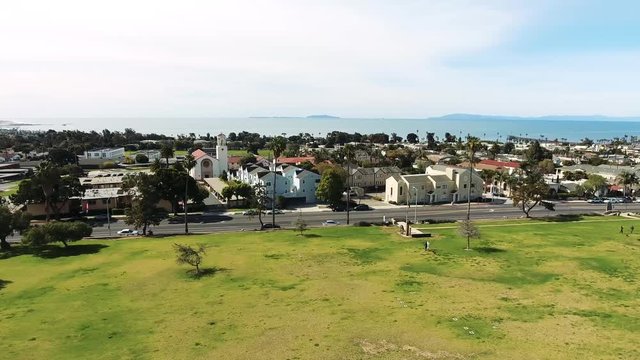 Aerial Flyover Panning Right - Southern California coastal town with islands in the distance