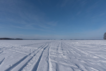 Fototapeta na wymiar Trails and prints on frozen lake