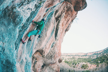 A woman climbs the rock.