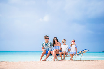 Young beautiful family on white beach