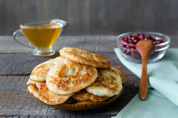 Russian-style fritters on dark wooden background