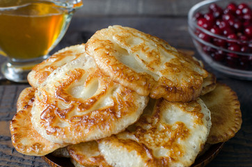 Russian-style fritters on dark wooden background