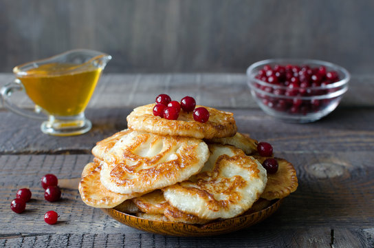 Russian-style fritters on dark wooden background