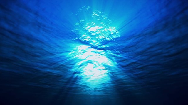 blue ocean surface seen from underwater, looped slow motion waves and beams, rays of sunlight shining through, 4K seamless loop animation