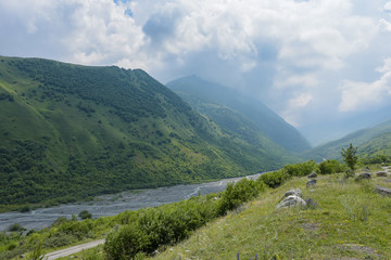 Fototapeta na wymiar The Genaldon river in Karmadon Gorge and summer view. North Ossetia, Russia. The Caucasus Mountains.