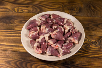 Raw chicken hearts on wooden table