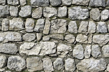 Old white and grey stones wall texture. Abstract grunge uneven bricks and concrete background. Multicolored stones and bricks rock pattern