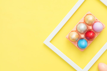 Flat lay top view colorful easter egg painted in pastel colors composition on yellow pastel color background. Easter day background top view with copy space.