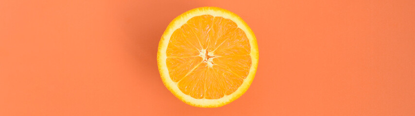 Top view of a one orange fruit slice on bright background in orange color. A saturated citrus...