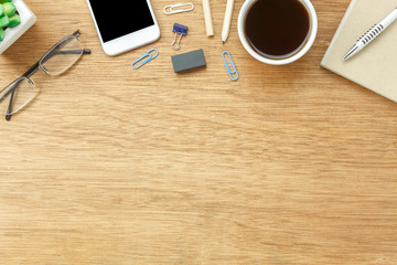 Table top view aerial image stationary on office desk background concept.Flat lay objects the cup of coffee with essential accessory.Items on modern brown wooden at home studio.Space for add text.