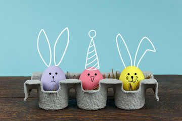 Shot of arrangement decoration & sign Happy Easter holiday background concept.Colorful Bunny Easter eggs on modern rustic brown wooden with blue paper at office desk with copy space.pastel tone.