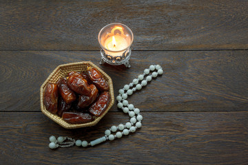 Table top view decoration & food Ramadan Kareem festival background concept.Flat lay of Date fruit & Rosary with lantern on modern rustic brown wooden at office desk.Free space creative design text.