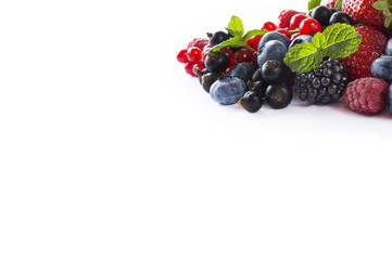 Mix berries on a white background. Ripe blueberries, blackberries, currants and strawberries. Various fresh summer berries on white background. Top view.