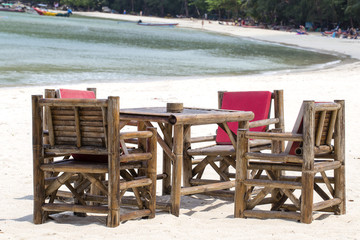 Table and bamboo chairs in tropical beach next to the sea , Thailand. Close up