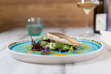 Roasted char on truffled avocado salad, wild herbs and carrot oil - blue plate