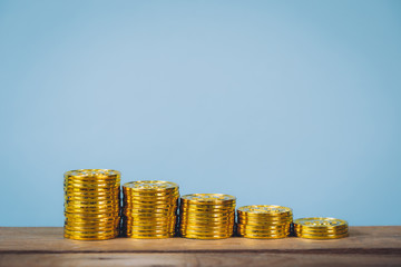 Gold coins stack over blue pastel background with copy space. Business growing and Money saving concept