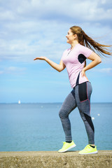 Woman exercising next to sea