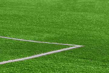 Obraz premium A close-up of an artificial green football turf with a corner marking at the gate.