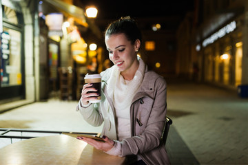 Attractive young woman using tablet in cafe