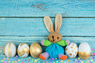 Happy Easter. Colorful easter eggs and rabbit on green grass.