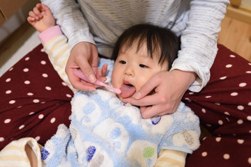 A child's mother brushing her teeth / One-year-old Japanese girl