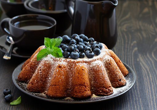 Vanilla cake (gugelhupf) with blueberries. dark background.