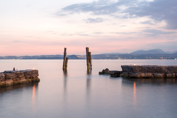 Naklejka premium punta san idillio lago di garda al tramonto molo porto