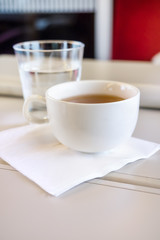 Tea cup with water over a white travel table