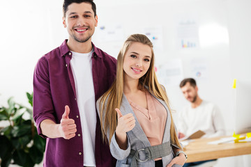 portrait of young marketing managers in office showing thumbs up