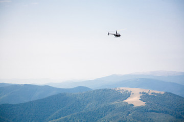 Fototapeta na wymiar helicopter in the mountains, summer landscape, transport, rescue