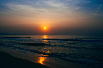 sunrise on the background of blue sky at summer sea