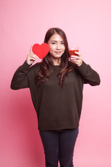 Young Asian woman with tomato juice and red heart.