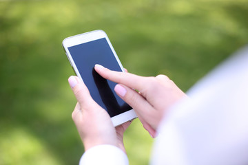 Woman using mobile smart phone in park.