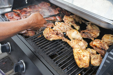 Man frying chicken meat on BBQ grill
