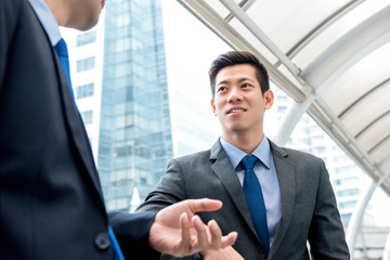 Young handsome Asian Chinese businessman talking with partner