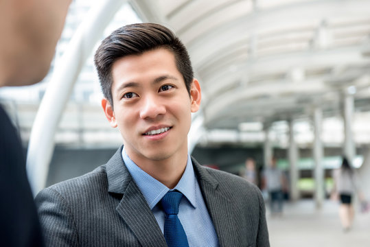 Asian Chinese Businessman Listening To Partner With Eye Contact