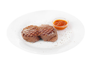 Steak beef, pork, lamb, grilled meat, barbecue, on a plate isolated white background. Tomato, spicy, red sauce. Juicy fillet, medium, strong roast. For the menu in the restaurant, bar Side view